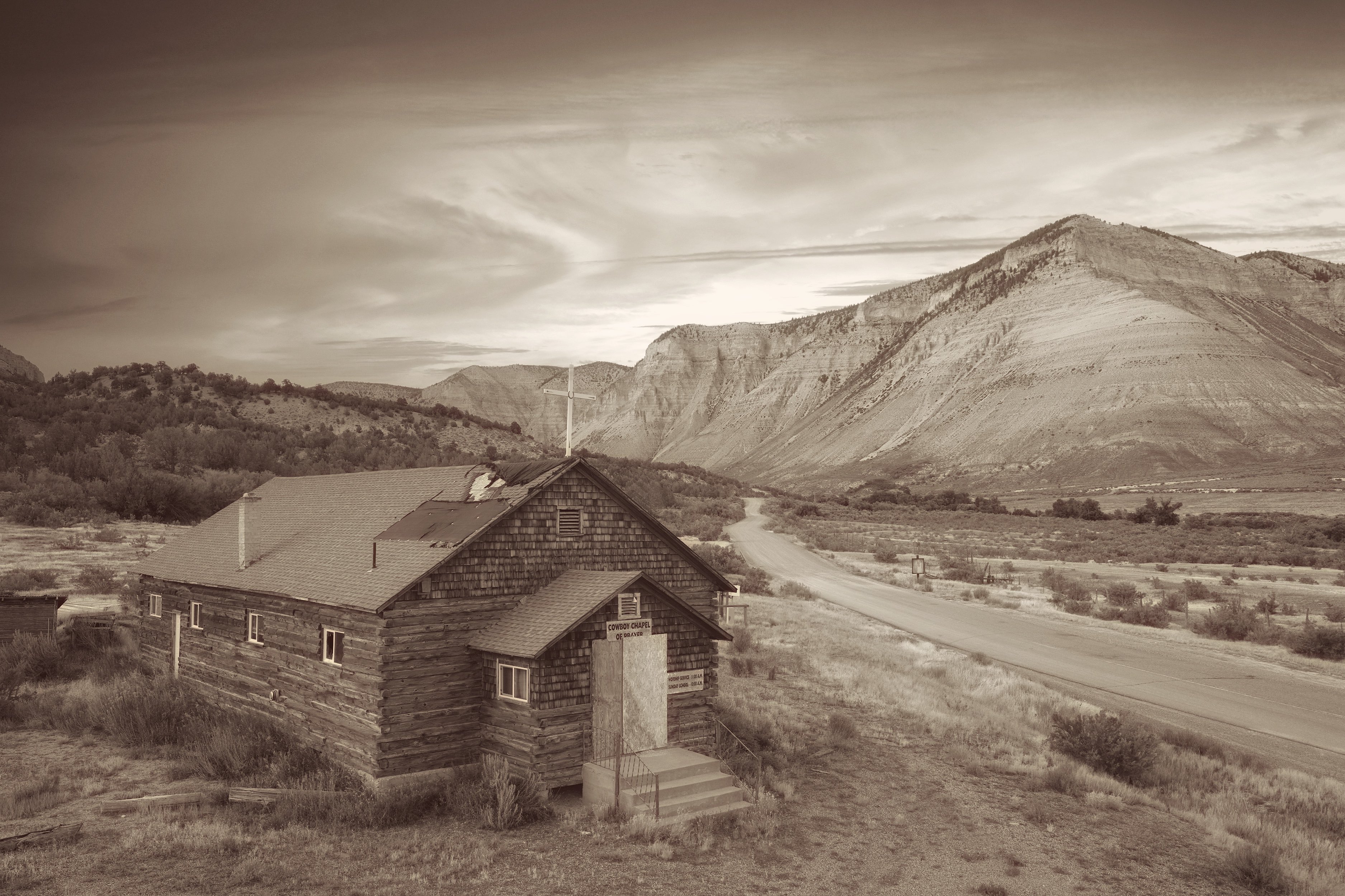 I worked in Photoshop and Snapseed. I added a different sky so that the top of the image wasn't blank, used sepia tones and reduced contrast/clarity. Removed telephone poles and wires as well as signs.